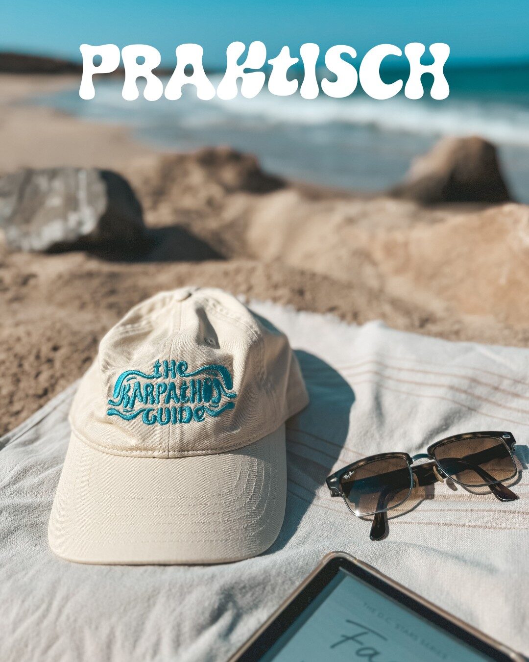 Flat lay van een een pet met de tekst The Karpathos guiide bij het strand