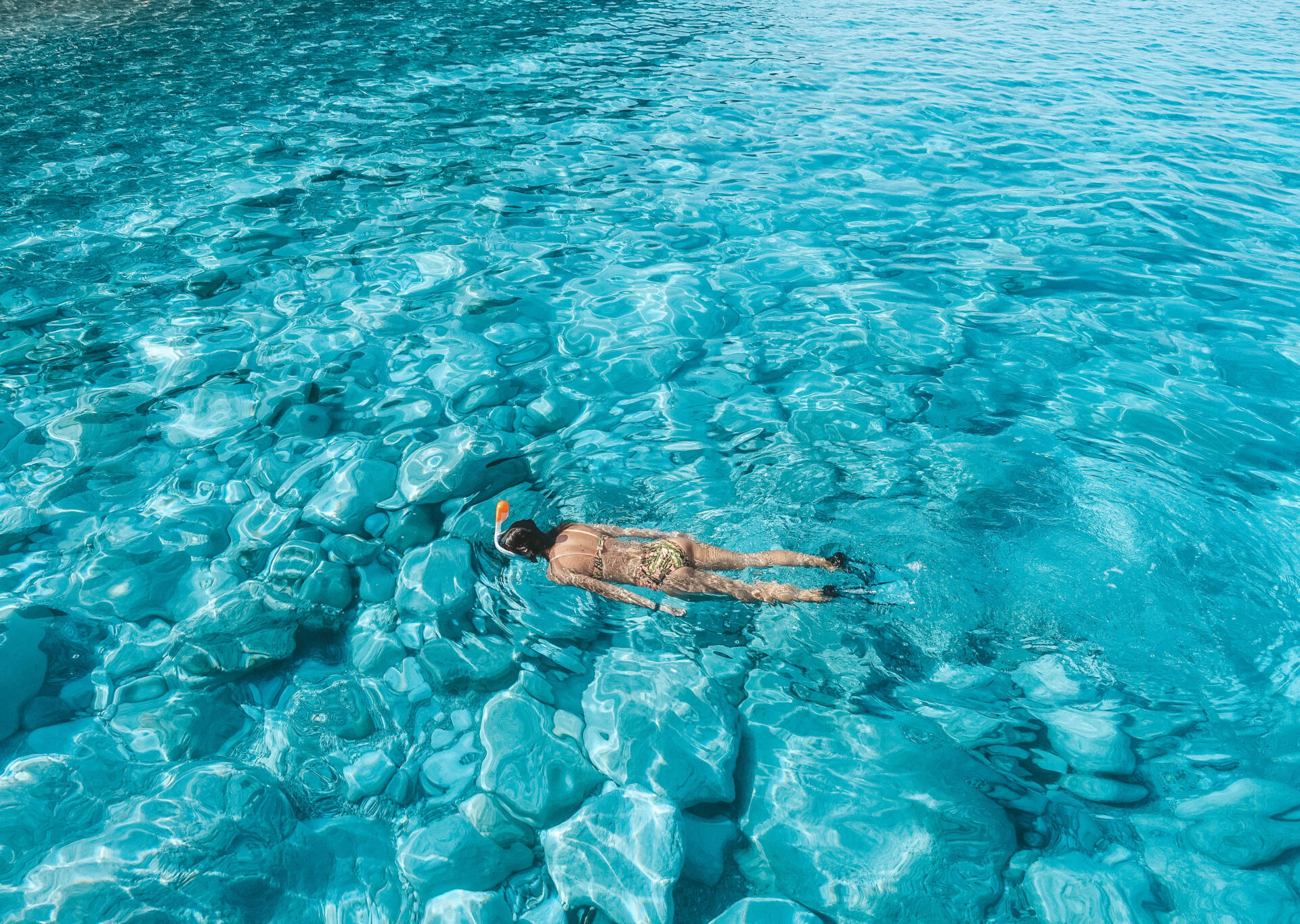 Toeristen snorkelen in helder turquoise water bij Karpathos